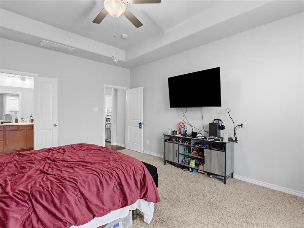 120 Garner Court Forney, TX 75126 - Photo 16 of 27 a bedroom with a bed and a flat screen tv