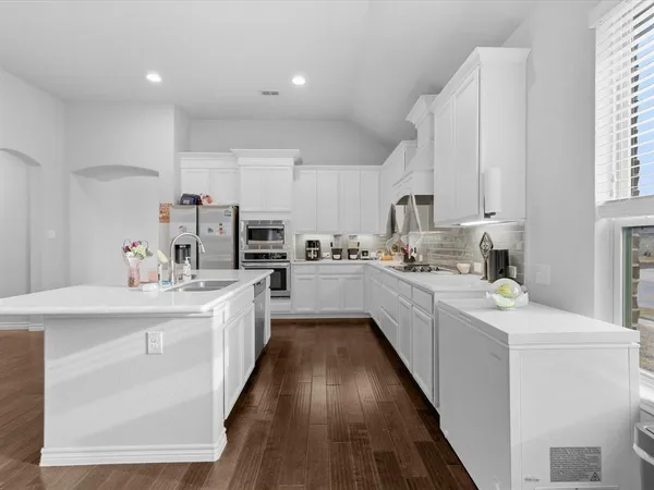 a large kitchen with stainless steel appliances sink a microwave and cabinets
