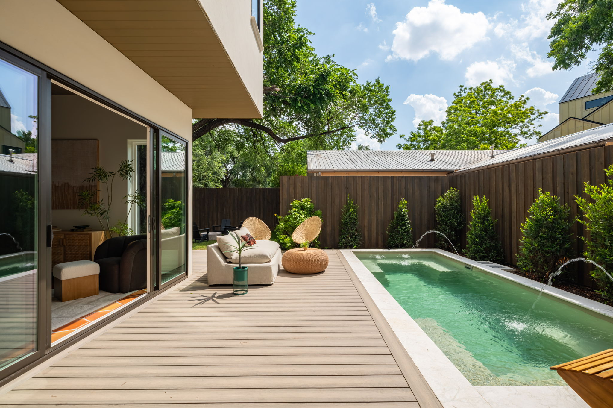 4713 Bolm Road Austin, TX 78702 - Photo 37 of 40 Outdoor living space featuring a rectangular pool with water features, a composite deck, and a wood privacy fence