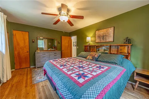 a bedroom with a bed dresser and a flat tv screen