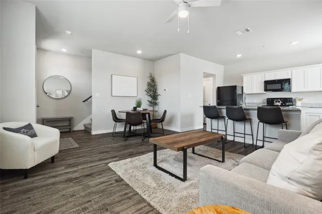 a living room with furniture and a wooden floor