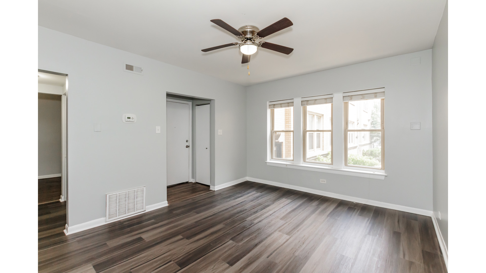 2400 North Kilbourn Avenue, Unit 2 Chicago, IL 60639 - Photo 2 of 10 a view of an empty room with wooden floor and a window
