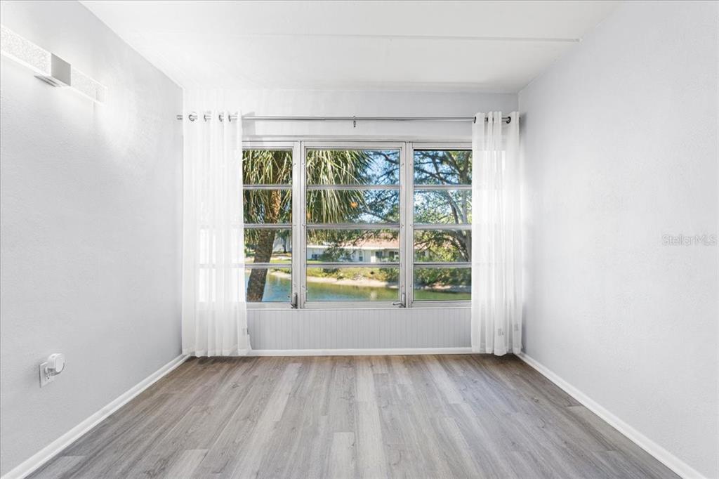 821 Patricia Avenue, Unit 202 Dunedin, FL 34698 - Photo 11 of 37 an empty room with wooden floor and windows