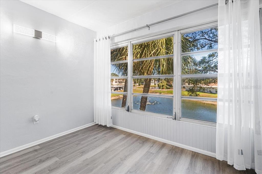 821 Patricia Avenue, Unit 202 Dunedin, FL 34698 - Photo 12 of 37 a view of an empty room with wooden floor and a window