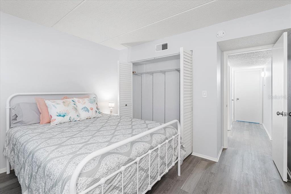 821 Patricia Avenue, Unit 202 Dunedin, FL 34698 - Photo 16 of 37 a bedroom with a bed and a mirror