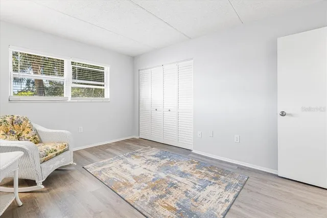 a view of a bedroom with wooden floor and window
