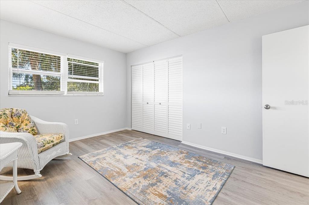 821 Patricia Avenue, Unit 202 Dunedin, FL 34698 - Photo 22 of 37 a view of a bedroom with wooden floor and window