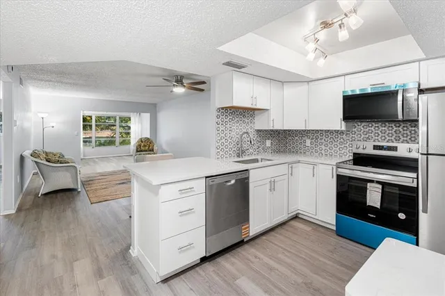a kitchen with stainless steel appliances a stove sink and microwave