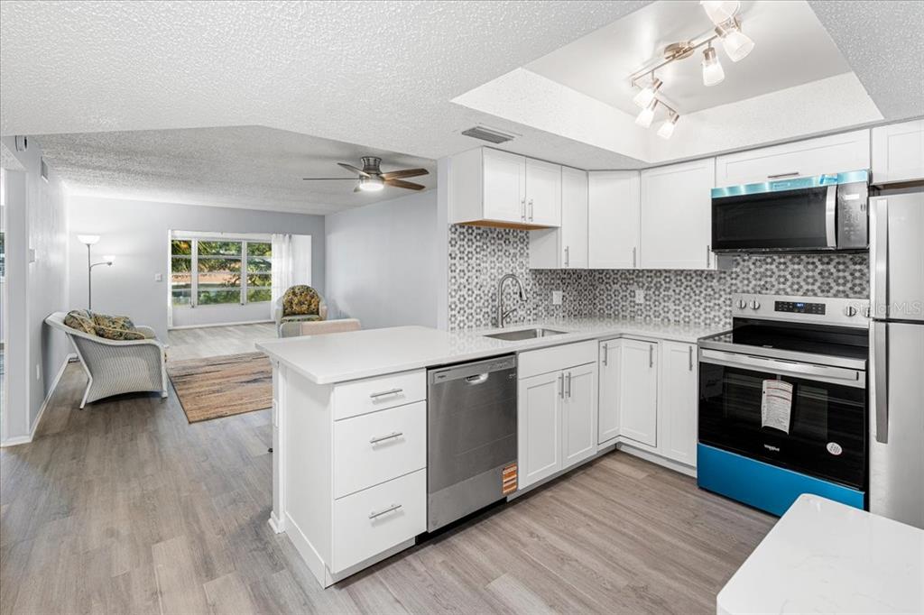 821 Patricia Avenue, Unit 202 Dunedin, FL 34698 - Photo 6 of 37 a kitchen with stainless steel appliances a stove sink and microwave