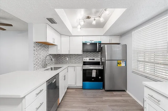 a kitchen with stainless steel appliances a refrigerator sink and microwave