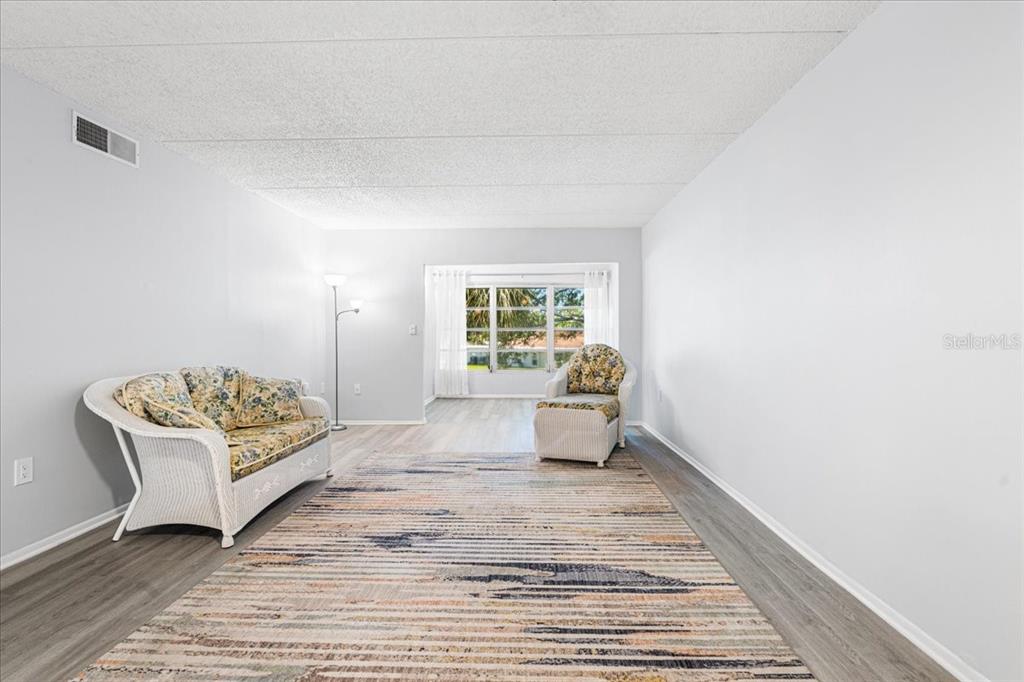 821 Patricia Avenue, Unit 202 Dunedin, FL 34698 - Photo 9 of 37 a spacious bedroom with a bed and a window