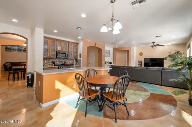 a view of a dining room with furniture and a kitchen view