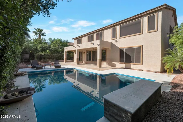 a view of house with swimming pool and outdoor seating