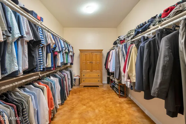 a view of walk in closet with clothes and shoes