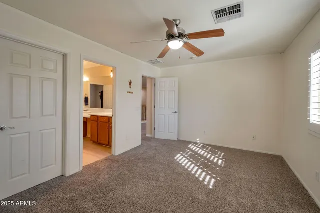 an empty room with closet and windows