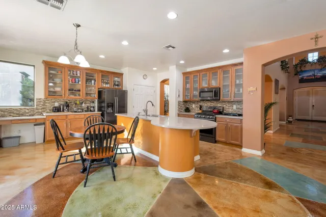 a dining room with stainless steel appliances granite countertop a table chairs and a kitchen view