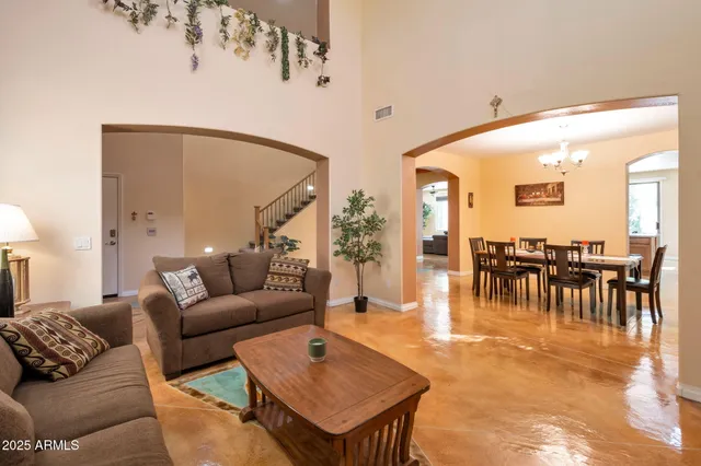 a living room with furniture and a dining table with garden view