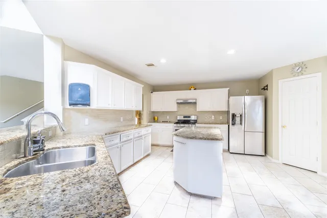 a bathroom with a granite countertop sink a toilet and shower