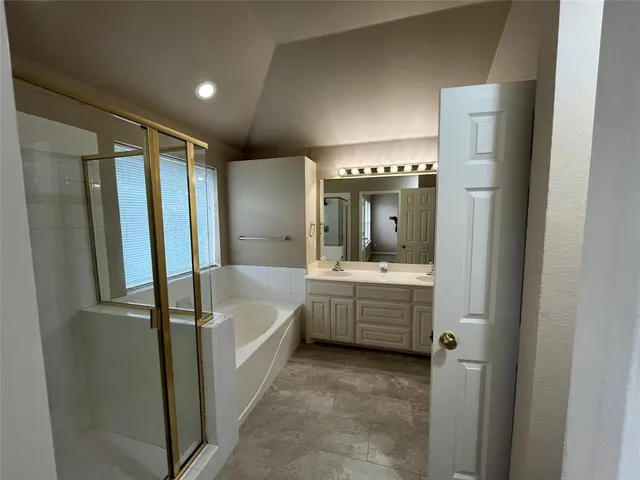 a bathroom with a tub sink shower and mirror