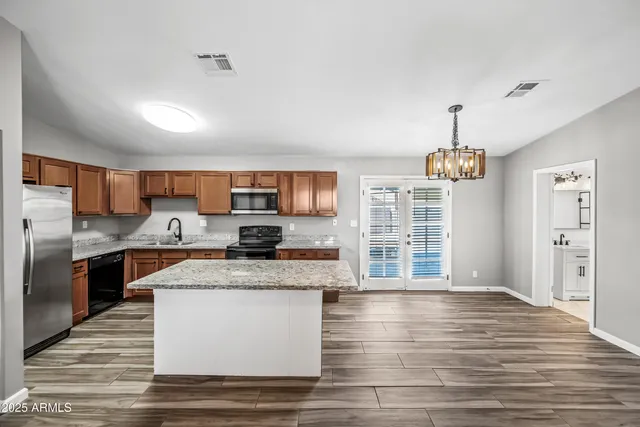 a large kitchen with stainless steel appliances granite countertop a stove oven and a refrigerator