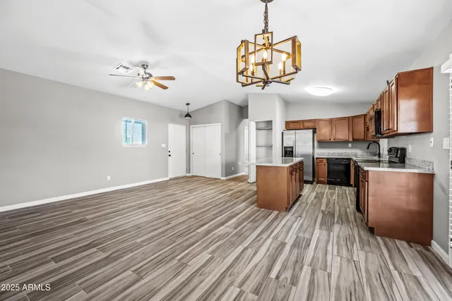 a view of a kitchen with a sink and dishwasher a oven with wooden floor