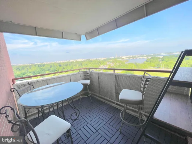 a view of roof deck with dining table and chair with wooden floor