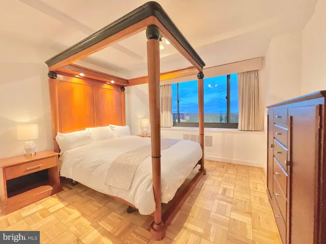 a spacious bedroom with a bed and wooden floor