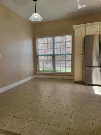 a view of an empty room with a kitchen