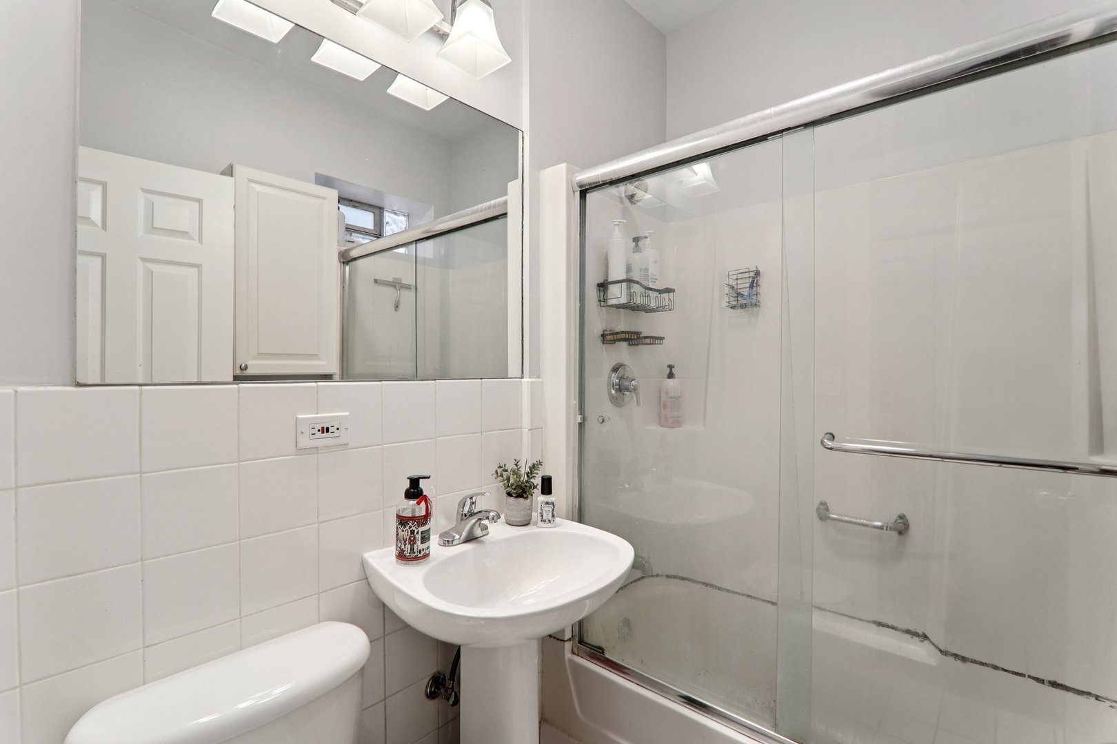 7023.5 North Sheridan Road, Unit 3S Chicago, IL 60626 - Photo 12 of 19 a bathroom with a sink toilet and shower
