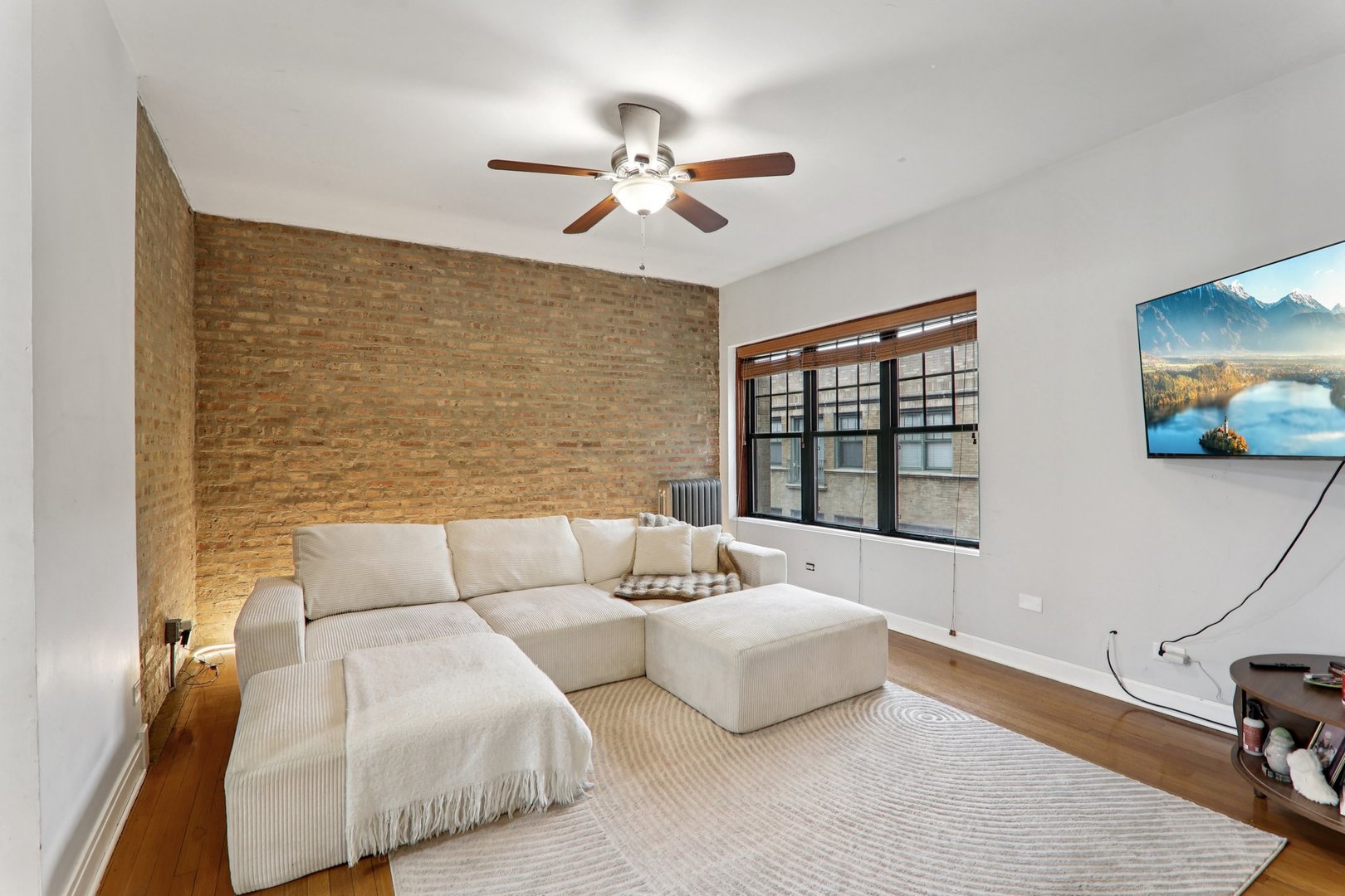 7023.5 North Sheridan Road, Unit 3S Chicago, IL 60626 - Photo 3 of 19 a living room with couches a fireplace and a flat screen tv