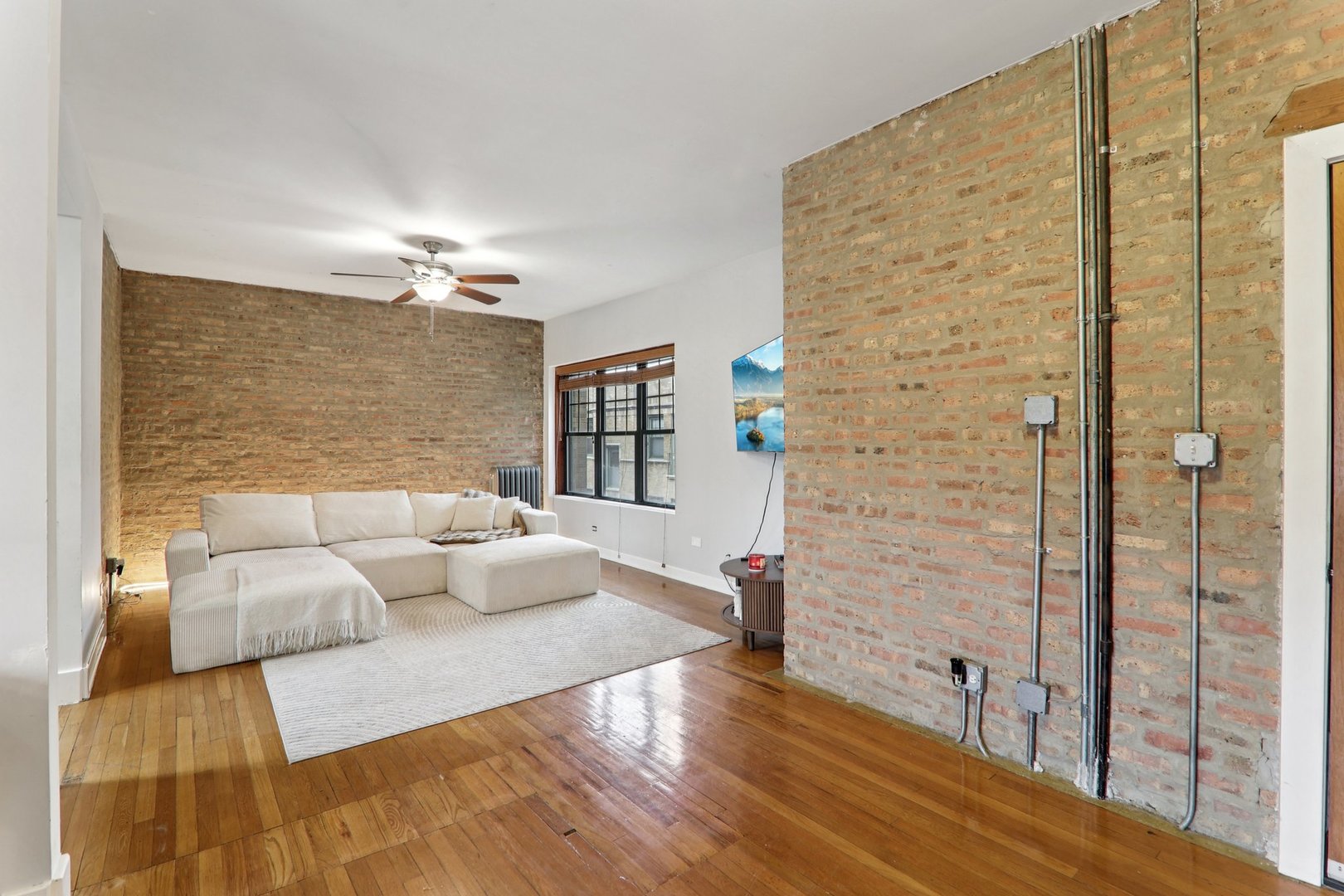 7023.5 North Sheridan Road, Unit 3S Chicago, IL 60626 - Photo 4 of 19 a living room with furniture and wooden floor