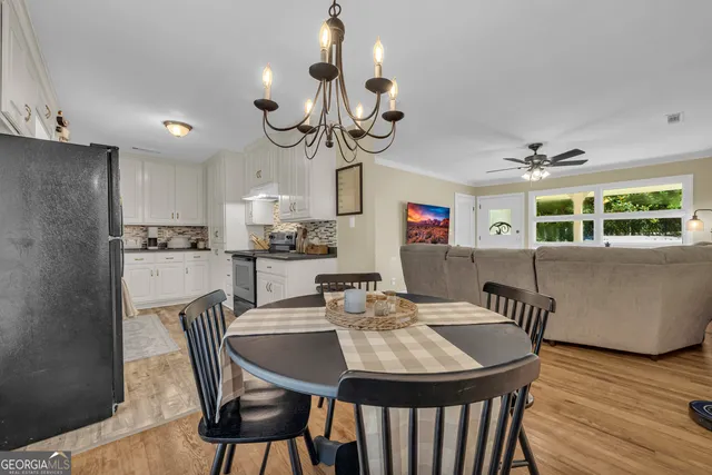 a kitchen with stainless steel appliances granite countertop a refrigerator a sink dishwasher a stove and white countertops with wooden floor