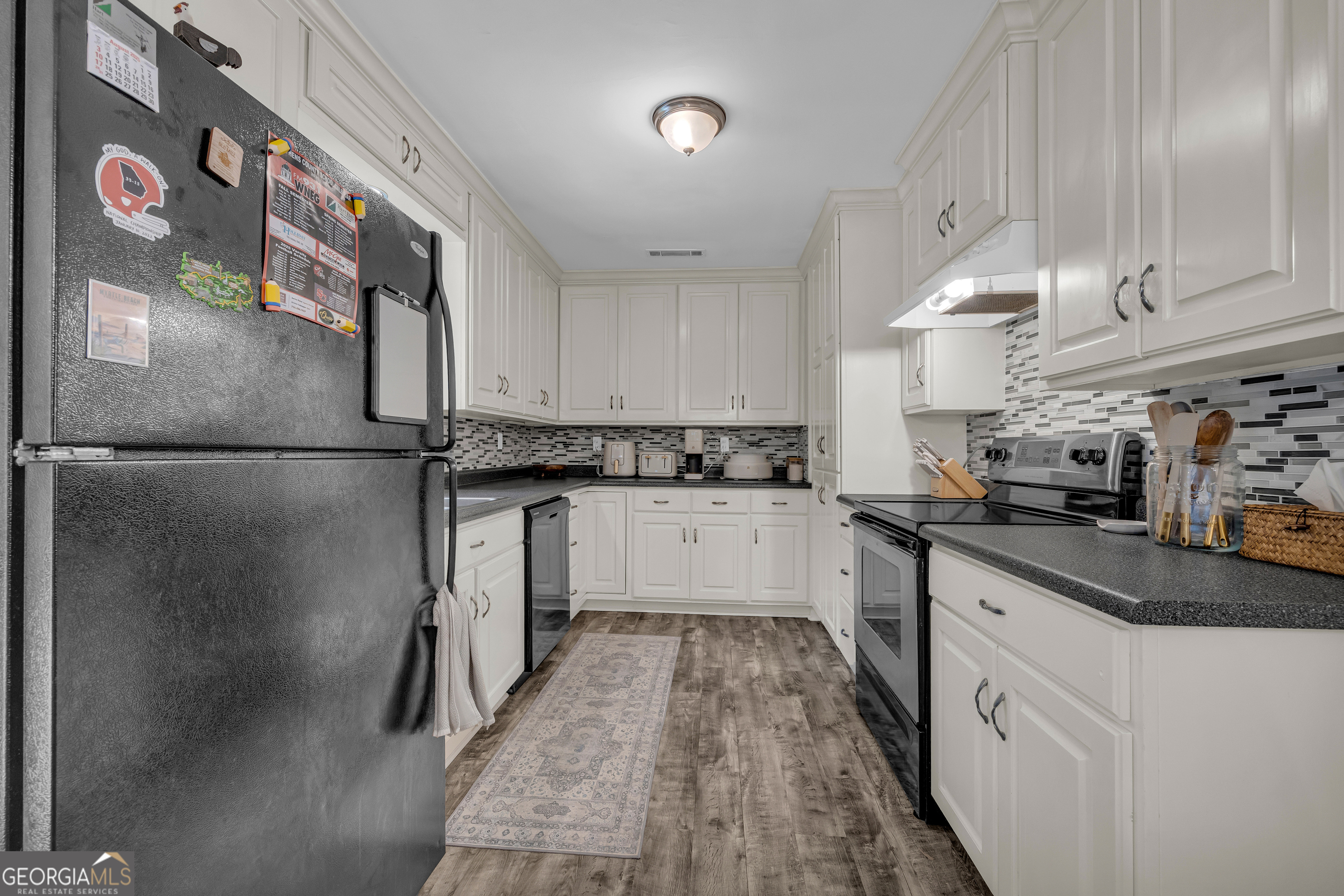1168 Rosedale Street Toccoa, GA 30577 - Photo 12 of 23 a kitchen with stainless steel appliances granite countertop a refrigerator a sink dishwasher a stove and white countertops with wooden floor