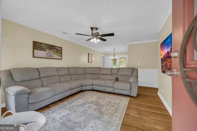 a living room with furniture and a wooden floor