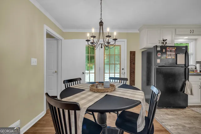 a view of a dining room with furniture a chandelier and wooden floor
