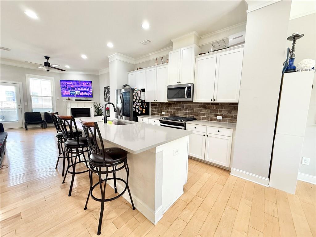 1817 Hislop Lane, Unit 7 Atlanta, GA 30345 - Photo 8 of 32 a kitchen with stainless steel appliances kitchen island granite countertop a stove a sink a microwave a dining table and chairs with wooden floor