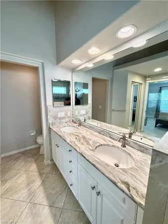 a bathroom with a granite countertop sink a mirror and a shower