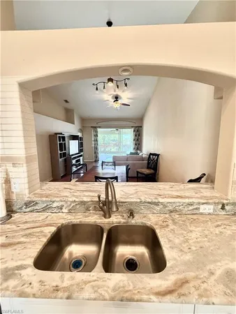 a kitchen with a sink and a stove with wooden floor