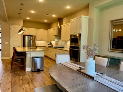 a kitchen with kitchen island a counter top space a sink stainless steel appliances and cabinets