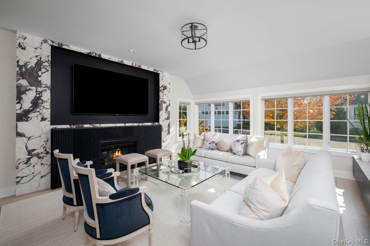 1 Primrose Lane Rye Brook, NY 10573 - Photo 13 of 42 Living area with wood finished floors, a premium fireplace, and lofted ceiling