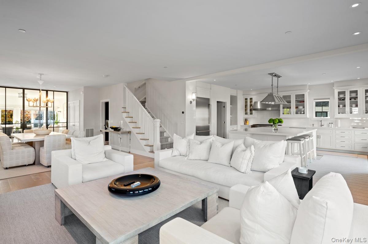 1 Primrose Lane Rye Brook, NY 10573 - Photo 5 of 42 Living room featuring light wood-type flooring, a chandelier, recessed lighting, stairway, and a wall of windows