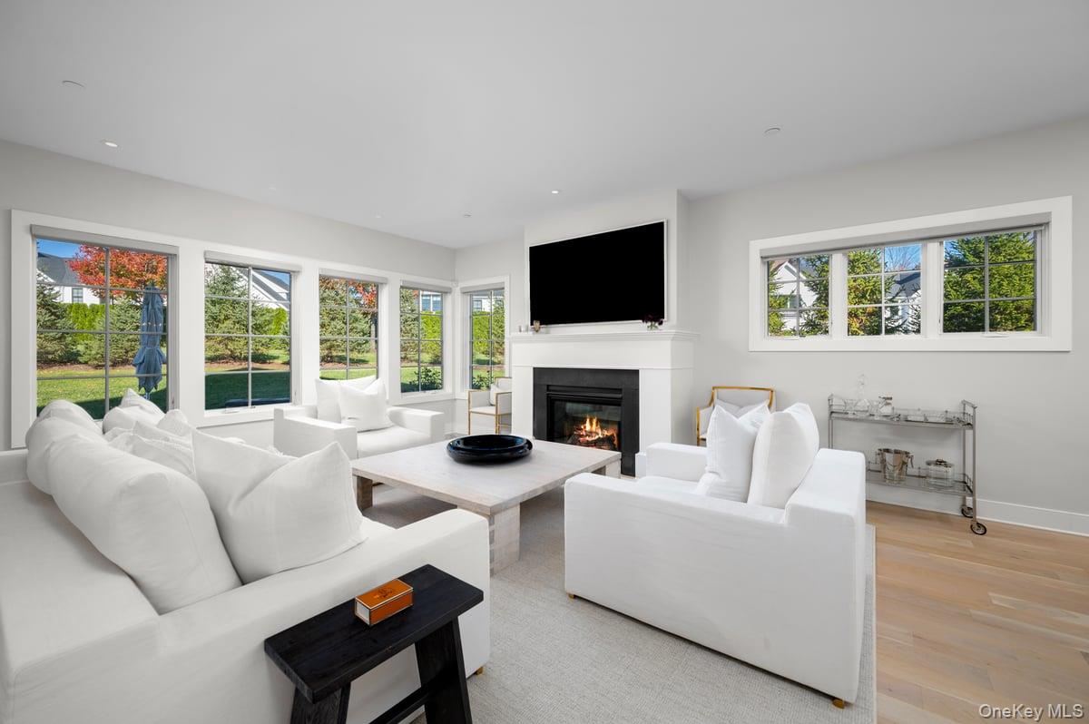 1 Primrose Lane Rye Brook, NY 10573 - Photo 6 of 42 Living room with light wood finished floors, a glass covered fireplace, and recessed lighting