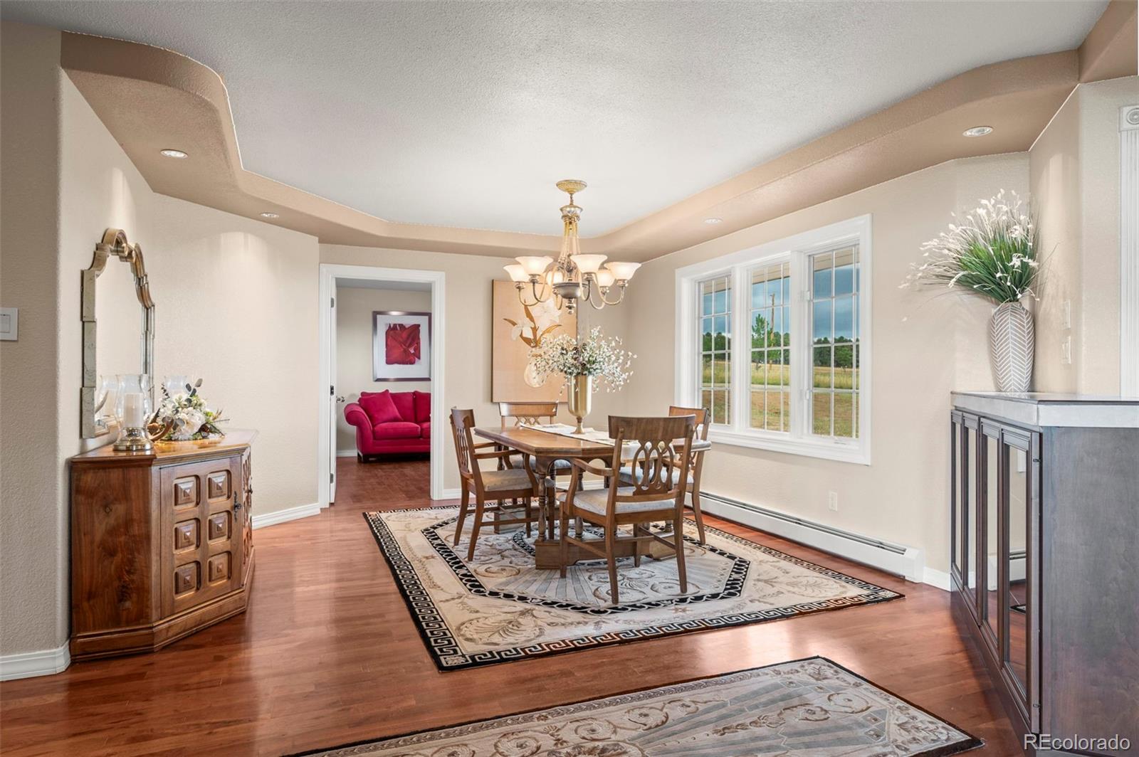 10650 Baxter Road Rye, CO 81069 - Photo 15 of 50 a dining room with wooden floor a chandelier a wooden table and chairs