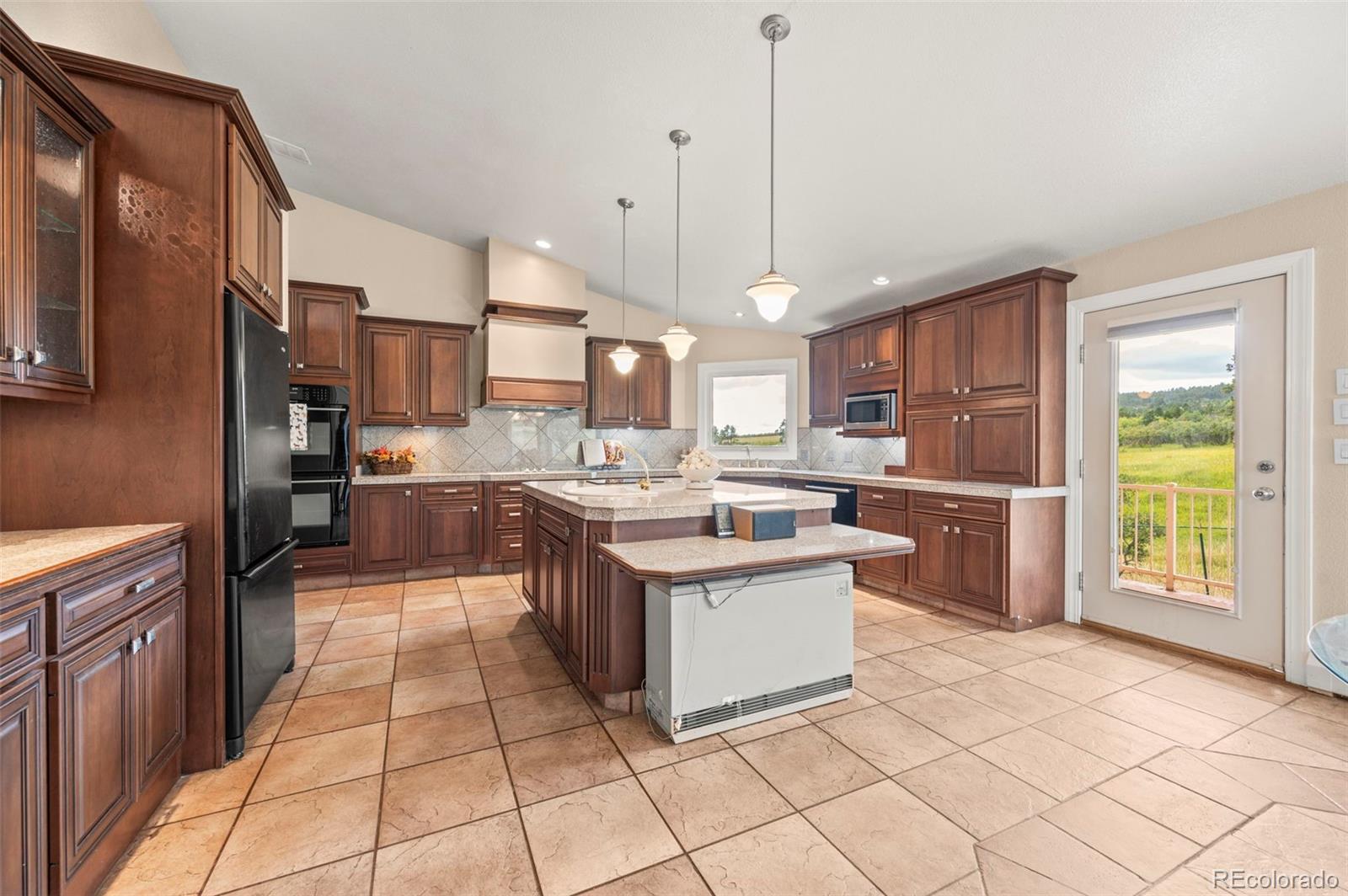 10650 Baxter Road Rye, CO 81069 - Photo 20 of 50 a kitchen with stainless steel appliances kitchen island granite countertop a stove a sink and a refrigerator