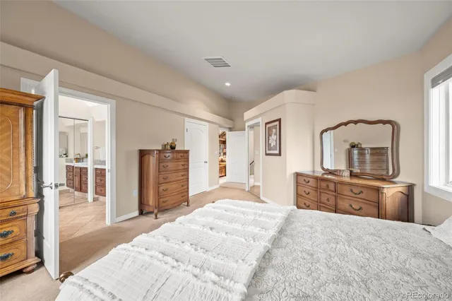 a bedroom with a bed dresser and a flat tv screen