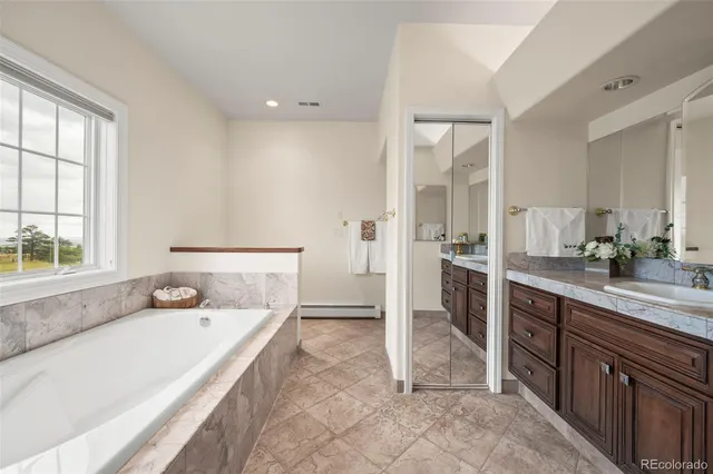 a spacious bathroom with a sink double vanity and a tub