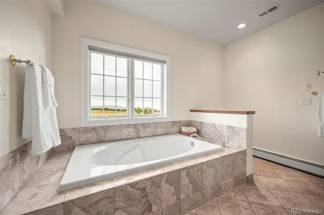 a spacious bathroom with bathtub and a bathtub