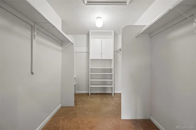 a view of walk in closet with empty racks
