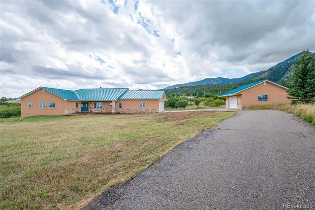 a view of a house with a yard and sitting area