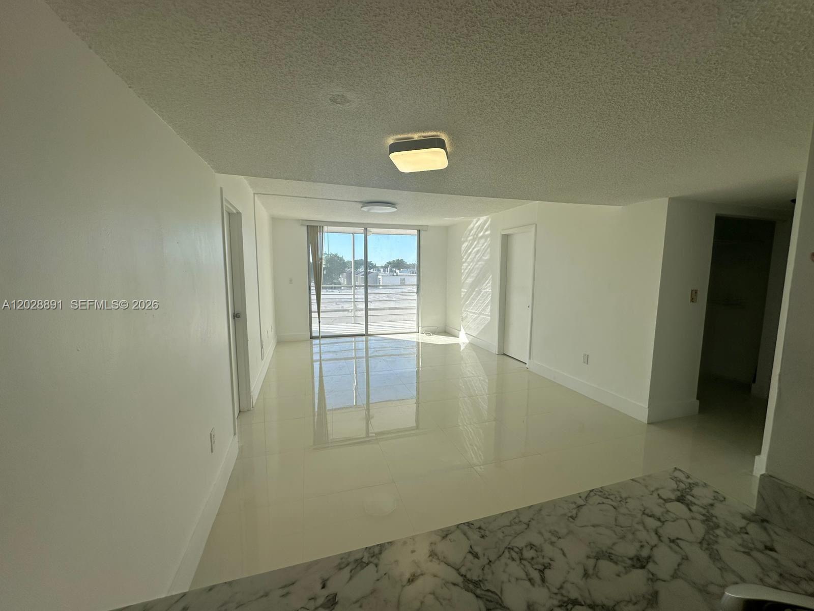 14170 Southwest 84th Street, Unit 402F Miami, FL 33183 - Photo 5 of 36 Living and Dining Rooms view from the Kitchen to the Balcony